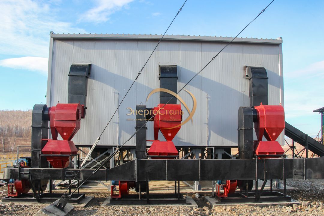 Сборка котельной с тремя котлами КВм-1,25 МВт. Видно технологическое основание, узлы подключения и доступ к обслуживанию. Механическая подача топлива и система золоулавливания.