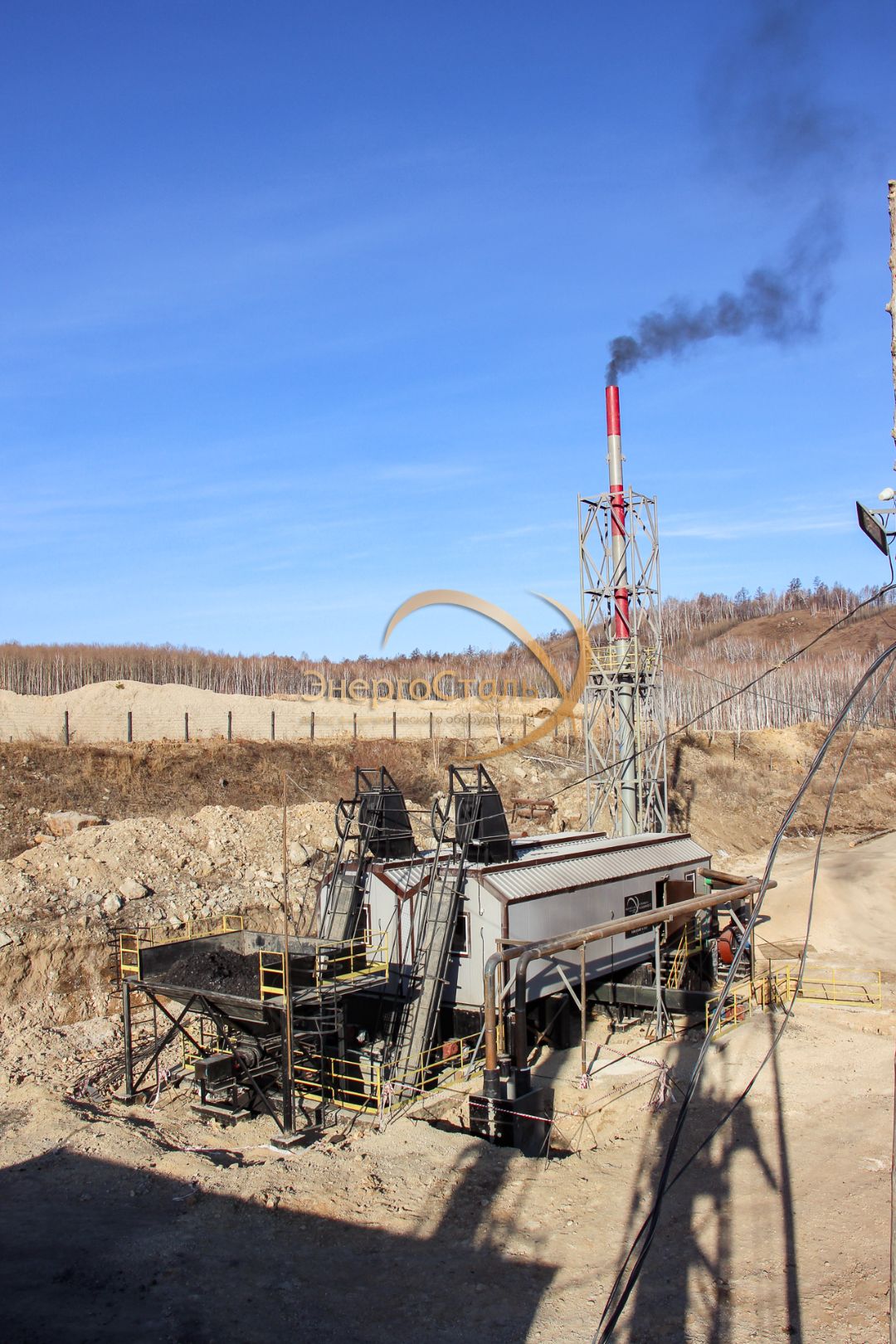 Две скип-шахты подают уголь к верхним люкам котлов. Ниже — бункер, сверху — галерея для ревизии. Газоход уводит дымовые газы на высокую трубу с растяжками — устойчивость к порывистому ветру и обледенению.