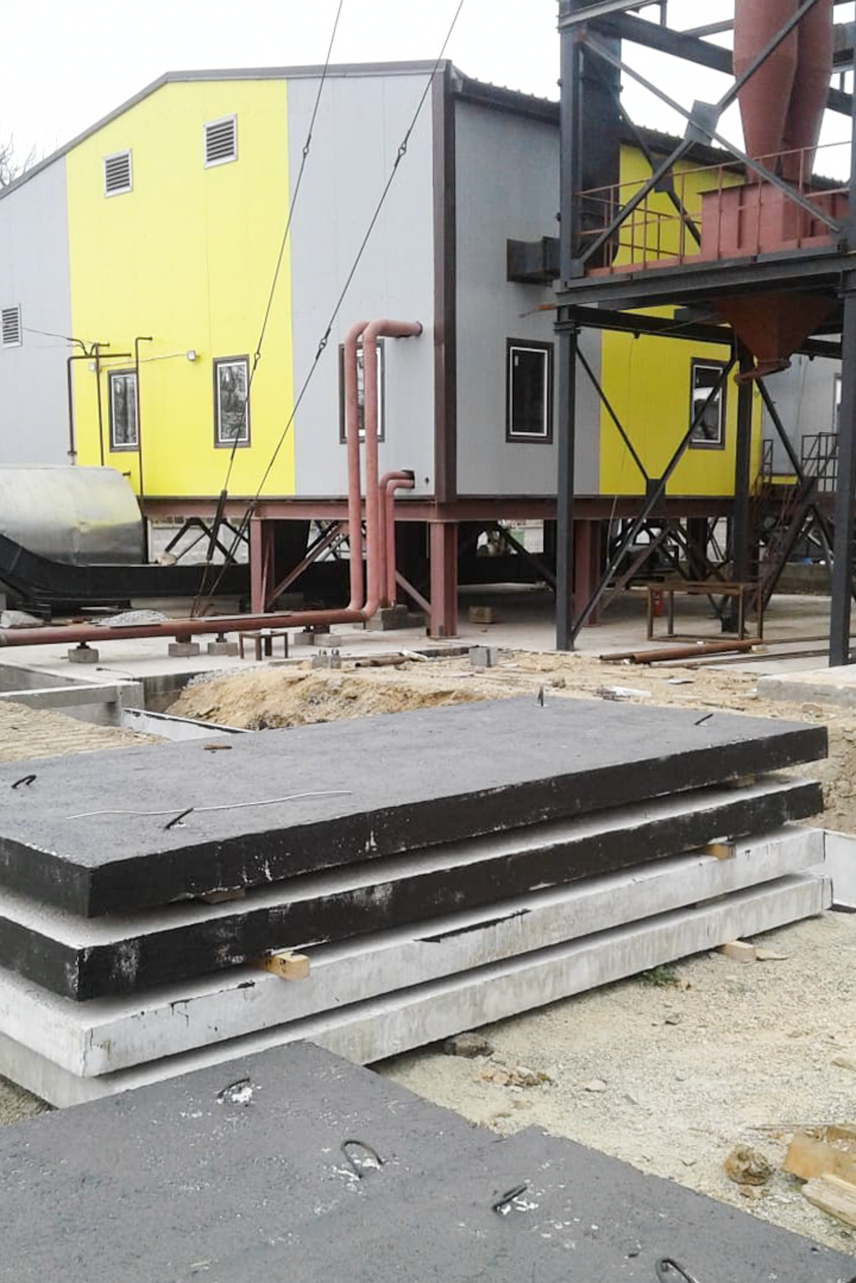 Главный фасад котельной со скиповыми шахтами. Здания собраны в контейнерном исполнении, установлены на бетонном основании с утеплённым перекрытием. На снимке — подача топлива к верхним загрузочным люкам.